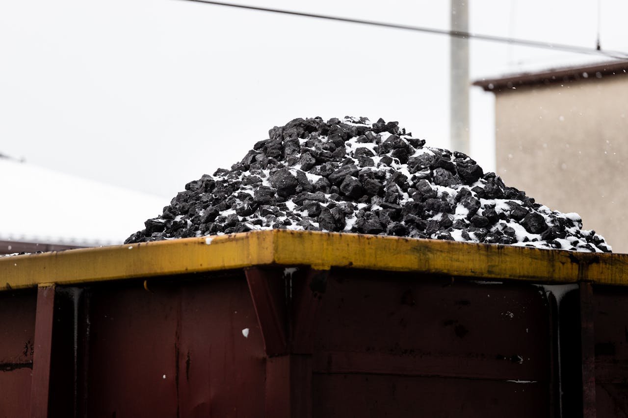 services-03 A heap of coal on a freight train car covered with snow, symbolizing transport and industry.